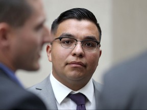 FILE - In this May 30, 2017, file photo, St. Anthony police officer Jeronimo Yanez stands outside the Ramsey County Courthouse while waiting for a ride in St. Paul, Minn. It was announced Monday, July 10, that Yanez, the Minnesota police officer acquitted in last year's fatal shooting of black motorist Philando Castile, has left the police department where he served. (David Joles/Star Tribune via AP, File)