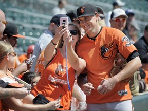 Terrie Busker, left, formerly of Baltimore, takes a selfie with Baltimore Orioles' Brad Brach, right, prior to the Orioles baseball game against the Minnesota Twins, Saturday, July 8, 2017, in Minneapolis. (AP Photo/Tom Olmscheid)