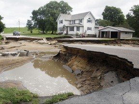 A section of North Oak Street is caved in and impassable Thursday, July 20, 2017, in Arcadia, Wis., following thunderstorms the night before that caused nearby Turton Creek to overflow its banks. Several hundred people evacuated their homes early Thursday in the small western Wisconsin community. (Chuck Miller/The Daily news via AP)