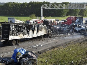 Investigators survey the scene of a multi-vehicle accident that claimed multiple lives on Tuesday, July 11, 2017, on westbound Interstate 70 just west of Bonner Springs, Kans. The crash closed the highway in both directions for about two hours. (Keith Myers/The Kansas City Star via AP)