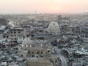 The sun sets behind destroyed buildings in the west side of Mosul, Iraq.