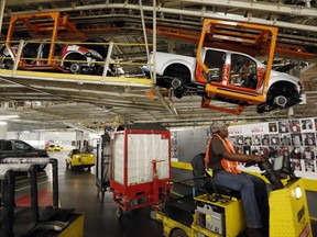 In this April 6, 2016 file photograph, vehicles are suspended above other installation stations as they are moved along the assembly line at the Nissan Canton Vehicle Assembly Plant in Canton, Miss. An employee vote on United Auto Workers representation scheduled for Aug. 3-4, has both Nissan and the union aggressively seeking workers support. (AP Photo/Rogelio V. Solis)