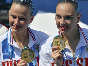 Gold medal winners Svetlana Kolesnichenko, left, and Alexandra Patskevich, of Russia, pose for photographers during the awarding ceremony of the women's duet free synchronized swimming final free routine of the 17th FINA World Championships in the City Park venue, in Budapest, Hungary, Thursday, July 20, 2017. (Zsolt Czegledi/MTI via AP)