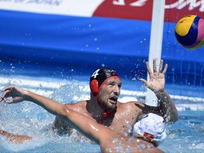 CORRECTS NAME OF PHOTOGRAPHER - Duro Radovic, left, of Montenegro and Nicolas Constantin-Bicari of Canada challenge for the ball during their men's water polo Group A first round match Montenegro vs Canada at the Swimming World Championships in Hajos Alfred National Swimming Pool in Budapest, Hungary, Monday, July 17, 2017. (Balazs Cagany/MTI via AP)