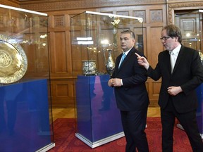 Hungarian Prime Minister Viktor Orban, left, and Director General of the Museum of Fine Arts of Budapest Laszlo Baan observe the exhibited Seuso-treasures after they announced that the Hungarian Government has acquired and repatriated the final seven pieces of the unique, priceless, ancient Roman silver treasure known as the Seuso-treasure during their exceptive press conference in the Hunting Room of the Parliament in Budapest, Hungary, Wednesday, July 12, 2017. (Tibor Illyes/MTI via AP)
