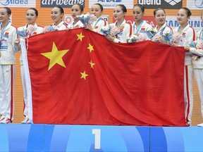 Members of the gold medal winner Team China celebrate with their national flag on the podium during the awarding ceremony of women's team free combination synchronized swimming final of the 17th FINA World Championships 2017 in the City Park venue, in Budapest, Hungary, 22 July 2017. (Szolt Czegledi/MTI via AP)