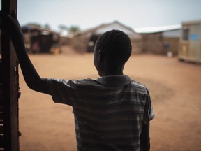 In this photo taken Saturday, May 13, 2017, thirteen-year-old boy Batista, who five months ago was drugged and raped in the middle of the night, stands in the doorway of a psychosocial support clinic in a camp for the internally-displaced in Wau, South Sudan. Four years into South Sudan's devastating civil war, the world's youngest nation is reeling from sexual violence on a "massive scale," a new Amnesty International report says Monday, July 24, 2017. (AP Photo/Bruno Bierrenbach Feder)