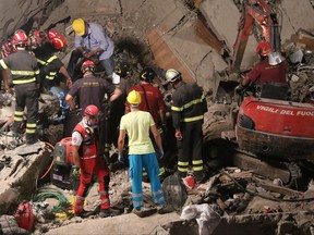 Rescuers work amid the rubble of a building that collapsed in Torre Annunziata, near Naples, southern Italy, Friday, July 7, 2017. A five-story apartment block collapsed early Friday near the southern Italian city of Naples, and authorities were digging by hand to find anyone who may have been trapped. (Ciro Fusco/ANSA via AP)