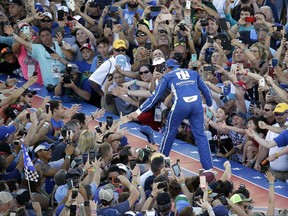 Dale Earnhardt Jr. greets fans during driver introductions for the NASCAR Cup auto race at Daytona International Speedway, Saturday, July 1, 2017, in Daytona Beach, Fla. (AP Photo/John Raoux)
