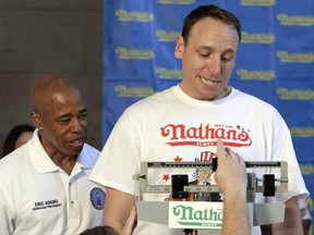 Current men's champion Joey Chestnut, right, of San Jose, Calif., watches the scale during his weigh-in for the 2017 Nathan's Hot Dog Eating Contest, in Brooklyn Borough Hall, in New York, Monday, July 3, 2017. Looking on with him is Brooklyn Borough President Eric Adams. Chestnut weighed-in at 221.5 pounds. (AP Photo/Richard Drew)