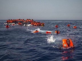 African migrants try to reach a Spanish NGO Proactiva Open Arms rescue ship after falling from a punctured rubber boat in the Mediterranean Sea, about 12 miles north of Sabratha, Libya on Sunday, July 23, 2017. On Wednesday, authorities said dozens of migrants were deliberately drowned off the coast of Africa.