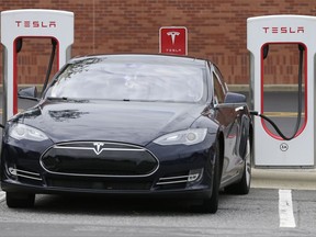In this Saturday, June 24, 2017, photo, a Tesla car recharges at a charging station at Cochran Commons shopping center in Charlotte, N.C. On Monday, July 3, 2017, Tesla CEO Elon Musk sent out a tweet saying that the company anticipates reaching production of 20,000 Model 3 cars per month in December. That figure is less than previous estimates. Tesla's shares are shaping up to possibly have their worst week of the year so far as lower-than-expected production, increased competition and a review from an industry group weigh on the electric carmaker. ()