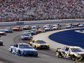 Driver Martin Truex Jr., bottom right, leads the pack going into the first turn of the NASCAR Cup Series 301 auto race at the New Hampshire Motor Speedway in Loudon, N.H., Sunday, July 16, 2017.(AP Photo/Charles Krupa)