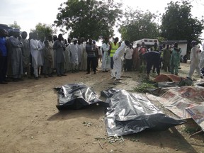 People mourn over the bodies of suicide bomb attack victims in a village near Maiduguri, Nigeria, Wednesday, July 12, 2017. Four Boko Haram suicide bombers killed over a dozen people in a series of attacks that targeted a civilian self-defense force and the people who gathered to mourn their deaths, police in Nigeria said Wednesday. It was the deadliest attack in months in the northeastern city of Maiduguri, the birthplace of Boko Haram's eight-year insurgency. (AP Photo/Jossy Ola)