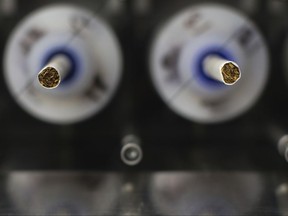 In this Thursday, Nov. 10, 2016 photo, test cigarettes sit in a smoking machine in a lab at the Centers for Disease Control and Prevention in Atlanta. On Friday, July 28, 2017, the U.S. Food and Drug Administration announced that it wants to lower nicotine levels in cigarettes so they aren't so addictive. (AP Photo/Branden Camp)