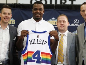 FILE - In this July 13, 2017, file photo, Denver Nuggets new NBA basketball forward Paul Millsap, second from left, holds up his new jersey as Josh Kroenke, team president and governor, left, Tim Connelly, president of basketball operations and Arturas Karnisovas, general manager of the Nuggets, join in for a photograph during Millsap's introduction to the media at a news conference in Denver. The NBA has for years had an issue with the Western Conference being superior to the East, but next season promises to have the widest talent gap yet after a flurry of stars left their teams in the East to try to challenge the mighty Warriors in the West. (AP Photo/David Zalubowski, File)