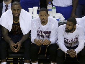 FILE - In this June 1, 2017, file photo, Cleveland Cavaliers forward LeBron James, from left, sits on the bench with center Tristan Thompson and guard Kyrie Irving during the second half of Game 1 of basketball's NBA Finals against the Golden State Warriors, in Oakland, Calif. All-Star point guard Kyrie Irving recently asked to be traded. (AP Photo/Ben Margot, File)