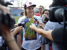 FILE - In this Aug., 24, 2016, file photo, Olympic gold-medal swimmer Katie Ledecky talks to the media before a baseball game between the Baltimore Orioles and the Washington Nationals, in Washington. Ledecky shrugs off the notion that she's doing anything special. Ledecky will race every day for seven straight days at the world championships in Budapest, if all goes according to plan. (AP Photo/Nick Wass, File)