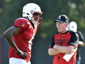 FILE - In this Aug. 5, 2016, file photo, Louisville head football coach Bobby Petrino, right, talks with freshman wide receiver Seth Dawkins as they go through workouts at their first public practice, in Louisville Ky. The Cardinals begin fall practice Monday with holes to fill on both sides of the ball after losing their final three games. (AP Photo/Timothy D. Easley, File)