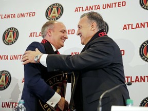 FILE - In this Sept. 28, 2016, file photo, Darren Eales, left, president of the Atlanta United MLS expansion soccer team, is embraced by the teams new head coach, Gerardo "Tata" Martino, at a news conference in Atlanta. Eales sensed potential for a rabid soccer fan base in Atlanta long before the first year expansion club first took the pitch. But the Atlanta United president had no idea how quickly it would blossom. (AP Photo/David Goldman, File)