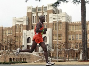 FILE - In this March 7, 2010, file photo, Moninda Marube runs past Little Rock Central High during the Little Rock Marathon race in Little Rock, Ark. Marube, of Kenya, says he had to outrun two charging bears while training in the woods Wednesday, July 5, 2017, near his home in Auburn, Maine. (AP Photo/Russell Powell, File)