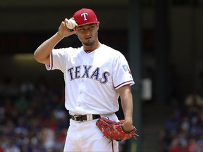 FILE - In this July 9, 2017, file photo, Texas Rangers starting pitcher Yu Darvish adjusts his hat as he works the first inning of a baseball game against the Los Angeles Angels, in Arlington, Texas. As the hours tick down to baseball's trade deadline, three standout pitchers remain at the center of attention. Sonny Gray, Justin Verlander and Yu Darvish each have the potential to help a contending team down the stretch, and if any of them are traded Monday, July 31, 2017, it would certainly spice up what has been a fairly pedestrian stretch of deals so far.  (AP Photo/Richard W. Rodriguez, File)