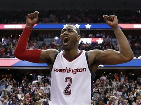 FILE - In this May 12, 2017, file photo, Washington Wizards guard John Wall celebrates as he stands on the scorer's table after Game 6 against the Boston Celtics in an NBA basketball second-round playoff series in Washington. A person familiar with the deal says that Wall has agreed to a $170 million, four-year contract extension with the Wizards that will start with the 2019 season. (AP Photo/Alex Brandon, File)