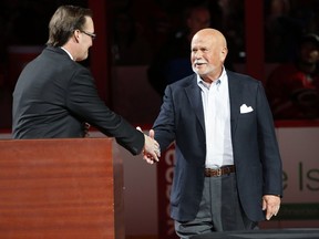 FILE - In this Feb. 13, 2016, file photo, Carolina Hurricanes broadcaster John Forslund greets Hurricanes owner Peter Karmanos Jr., right, before the teams' NHL hockey game against the New York Islanders in Raleigh, N.C. Karmanos is considering an offer from someone who wants to purchase the team. Spokesman Mike Sundheim said in a statement attributed to the team that Karmanos "also will continue to evaluate his other options, including retaining his ownership of the team." (AP Photo/Karl B DeBlaker, File)