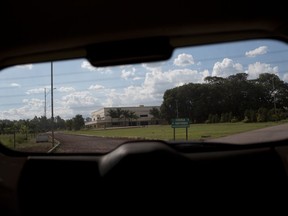 This Wednesday, March 29, 2017 photo shows the Word of Faith Fellowship church in Sao Joaquim de Bicas, Brazil, through a car window. Over the course of two decades, the U.S.-based mother church took command of this and another congregation in Brazil, applying a strict interpretation of the Bible and enforcing it through rigorous controls and physical punishment. (AP Photo/Silvia Izquierdo)