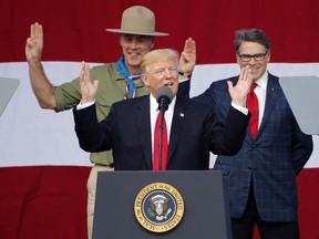 President DonaldTrump, front left, gestures as former boys scouts, Interior Secretary Ryan Zinke, left, Energy Secretary Rick Perry, watch at the 2017 National Boy Scout Jamboree at the Summit in Glen Jean, W.Va. in July.
