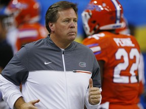 FILE - In this Dec. 3, 2016, file photo, Florida head coach Jim McElwain runs out on the field before the first half of the Southeastern Conference championship NCAA college football game against Alabama in Atlanta. The Southeastern Conference's Eastern Division will take center stage on Tuesday, July 11, 2017, at the league's annual media gathering. Florida, Georgia, Vanderbilt and Mississippi State are the four teams making the trek to SEC media days. (AP Photo/Butch Dill, File)