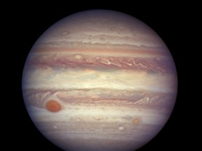 FILE - This April 3, 2017 file image made available by NASA shows the planet Jupiter when it was at a distance of about 668 million kilometers (415 million miles) from Earth. NASA's Juno spacecraft is about to give us our best look yet of Jupiter's swirling Great Red Spot. The spacecraft will fly directly above the monster storm Monday, July 10, passing about 5,600 miles or 9,000 kilometers above the cloud tops. (NASA, ESA, and A. Simon (GSFC) via AP, File)