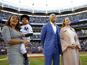 FILE - In this Sunday, May 14, 2017, file photo, Derek Jeter's sister Sharlee Jeter, left, holds her son Jaden, as retired New York Yankees shortstop Derek Jeter and his wife Hannah Jeter watch a video about Jeter's storied career during an on-field pregame ceremony retiring Jeter's number 2 at Yankee Stadium in New York. Jeter Publishing told The Associated Press on Wednesday, July 12, 2017, that Sharlee Jeter and Dr. Sampson Davis were collaborating on "The Stuff: Unlock Your Power to Overcome Challenges, Soar, and Succeed." The book is scheduled for May 2018. (AP Photo/Kathy Willens, File)