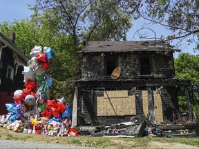 FILE - In this Tuesday, May 23, 2017, file photo, a balloon memorial sits outside the burnt home of a family that died in a fire in Akron, Ohio. Prosecutors said a grand jury on Thursday, July 27, 2017, indicted Stanley Ford in the May 15 fire in Akron that killed seven people. He had pleaded not guilty to charges including aggravated murder after his arrest in that blaze and remains jailed on $7 million bond. (AP Photo/Dake Kang, File)