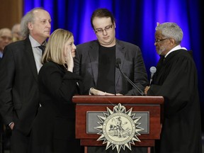 FILE - In this Friday, Sept. 25, 2015, file photo, Nashville Mayor Megan Barry, second from left, is sworn into office by Judge Richard Dinkins, right, with her husband, Bruce, left, and son, Max, second from right, in Nashville, Tenn. A statement released Sunday, July 30, 2017, from Megan and Bruce Barry, said their only child, Max Barry, died Saturday night in Denver from an apparent drug overdose. (AP Photo/Mark Humphrey, File)