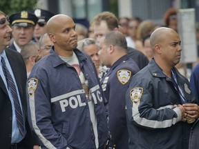 Police officers wait outside World Changers Church in the Bronx to enter a wake honoring slain police Officer Miosotis Familia, Monday July 10, 2017, in New York. Officer Miosotis Familia was shot and killed Wednesday, July 5, while sitting inside her police vehicle in the Bronx. (AP Photo/Bebeto Matthews)