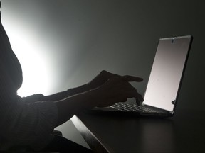 FILE - In this, Monday, Dec. 12, 2016, file photo illustration, a person types on a laptop, in Miami. A new Pew Research Center study says a whopping 41 percent of U.S. adults have experienced online harassment, ranging from offensive name-calling to stalking and sexual harassment. (AP Photo/Wilfredo Lee)