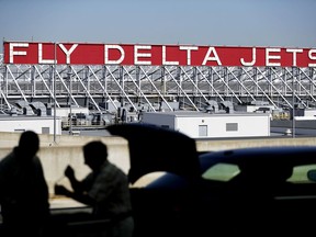 FILE - In this Thursday, Oct. 13, 2016, file photo, a Delta Air Lines sign overlooks the unloading area at Hartsfield-Jackson Atlanta International Airport, in Atlanta. On Tuesday, July 25, 2017, Delta Air Lines apologized after an argument between a pilot and a flight attendant delayed a Delta Connection flight on Monday from New York's LaGuardia Airport to Portland, Maine. The flight was operated by Delta subsidiary Endeavor Air. (AP Photo/David Goldman, File)