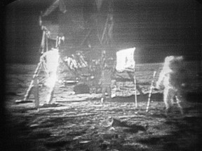 In this July 20, 1969 file photo, Apollo 11 astronaut Neil Armstrong, right, trudges across the surface of the moon leaving behind footprints. Moon dust collected by Armstrong during the first lunar landing is being sold at a New York auction.