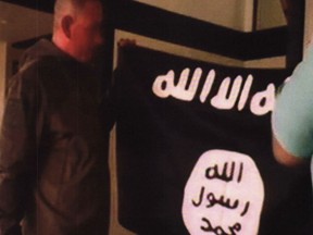 FILE - In this July 8, 2017 file image taken from FBI video and provided by the U.S. Attorney's Office in Hawaii on July 13, 2017, Army Sgt. 1st Class Ikaika Kang holds an Islamic State group flag after allegedly pledging allegiance to the terror group at a house in Honolulu. A federal grand jury in Hawaii has indicted Kang for attempting to provide material support to the Islamic State group. Kang was indicted Friday, July 21 after he was arrested by an FBI SWAT team on July 8. Kang was ordered held without bail. Because of the indictment, Kang will no longer have a preliminary hearing that was scheduled for Monday, July 24. (FBI/U.S Attorney's Office, District of Hawaii via AP, File)