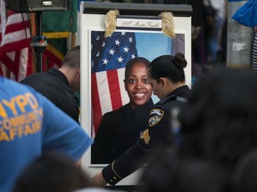 A portrait of slain New York police officer Miosotis Familia is placed on a podium before a tribute in her honor at the New York police department's 46th Precinct in the Bronx borough of New York, Saturday, July 8, 2017. Familia was shot to death early Wednesday, ambushed inside her command post by an ex-convict, who was later killed after pulling a gun on police. (AP Photo/Craig Ruttle)