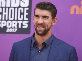 FILE - In this July 13, 2017 file photo, retired Olympic swimmer Michael Phelps arrives at the Kids' Choice Sports Awards at UCLA's Pauley Pavilion in Los Angeles.  Discovery Channel's Shark Week's opening lineup Sunday, July 23, includes "Phelps vs. Shark: Great Gold vs. Great White," with Phelps testing his speed against that of a great white shark. (Photo by Richard Shotwell/Invision/AP, File)