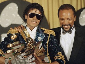 FILE - In this Feb. 28, 1984 file photo, Michael Jackson, left, holds eight awards as he poses with Quincy Jones at the Grammy Awards in Los Angeles. On Wednesday, July 26, 2017, a jury found that Jackson's estate owes Jones $9.4 million in royalties and production fees from "Billie Jean," "Thriller" and more of the superstar's  biggest hits. (AP Photo/Doug Pizac, File)