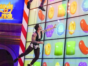 This image released by CBS shows former "Big Brother" contestants Frankie Grande and Caleb Reynolds competing in the new game show, "Candy Crush," premiering, Sunday, July 9 at 9 p.m. ET on CBS. (Sonja Flemming/CBS via AP)