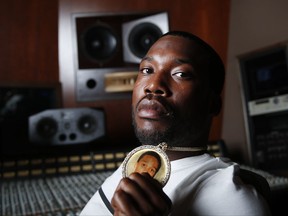 In this July 13, 2017 photo, rapper Meek Mill holds a necklace with a photo of the late rapper Lil Snupe on it during a portrait session to promote his new album "Wins & Losses," in Atlanta. (AP Photo/John Bazemore)