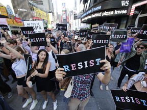 Protestors gather in Times Square, Wednesday, July 26, 2017, in New York. President Donald Trump declared a ban Wednesday on transgender troops serving anywhere in the U.S. military, catching the Pentagon flat-footed and unable to explain what it called Trump's "guidance." His proclamation, on Twitter rather than any formal announcement, drew bipartisan denunciations and threw currently serving transgender soldiers into limbo. (AP Photo/Frank Franklin II)