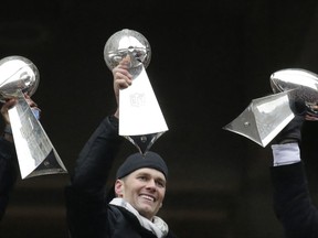 FILE - In this Feb. 7, 2017, file photo, New England Patriots quarterback Tom Brady holds a Super Bowl trophy, beside others the team previously had won, during a rally in Boston to celebrate the team's 34-28 win over the Atlanta Falcons in the NFL Super Bowl 51 football game in Houston. A Massachusetts farm is honoring Brady with a corn maze designed in his image. Sauchuk's Corn Maze and Pumpkin Patch in the town of Plympton said Sunday, July 16, that its 10th corn maze will feature the Patriots' star quarterback. (AP Photo/Elise Amendola, File)