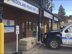 FILE - This Oct. 13, 2016, file photo shows the exterior of the police station in the town of Nederland, Colo. A man accused of leaving a bomb outside the police station in the small mountain town to avenge the killing of a fellow member of a hippie group in the 1970s is expected to plead guilty. David Michael Ansberry is expected to acknowledge Tuesday, July 18, 201, that he left a powerful bomb containing arsenic outside the Nederland Police Department on Oct. 11. (AP Photo/Sadie Gurman, File)
