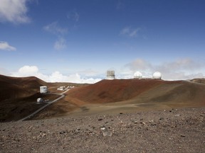 FILE - This Aug. 31, 2015, file photo shows telescopes on the summit of Mauna Kea on Hawaii's Big Island. A hearings officer is recommending that a construction permit be granted for a giant telescope planned for a Hawaii mountain summit that some consider sacred. Retired judge Riki May Amano is overseeing contested-case hearings for the Thirty Meter Telescope and issued her recommendation Wednesday, July 26, 2017. (AP Photo/Caleb Jones, File)