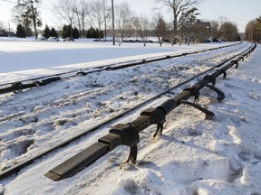 FILE- This Feb. 6, 2015, file photo shows the electrified third rail, bottom, that runs next to Metro-North Railroad tracks in Valhalla, N.Y. Federal investigators have concluded that a fiery crash between a commuter train and an SUV that killed six people in the suburbs in 2015 was extra deadly because of an unusual rail design, a U.S. official told The Associated Press on Monday, July 24, 2017. The rail was an under-running or under-riding design, in which a metal shoe slips underneath the electrified third rail, rather than skimming along the top. (AP Photo/Mark Lennihan, File)